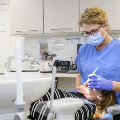 Dr Sarah Neale examining a patient's teeth in a treatment room