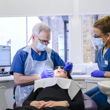 orthodontist and dental assistant treating a patient in a dental chair
